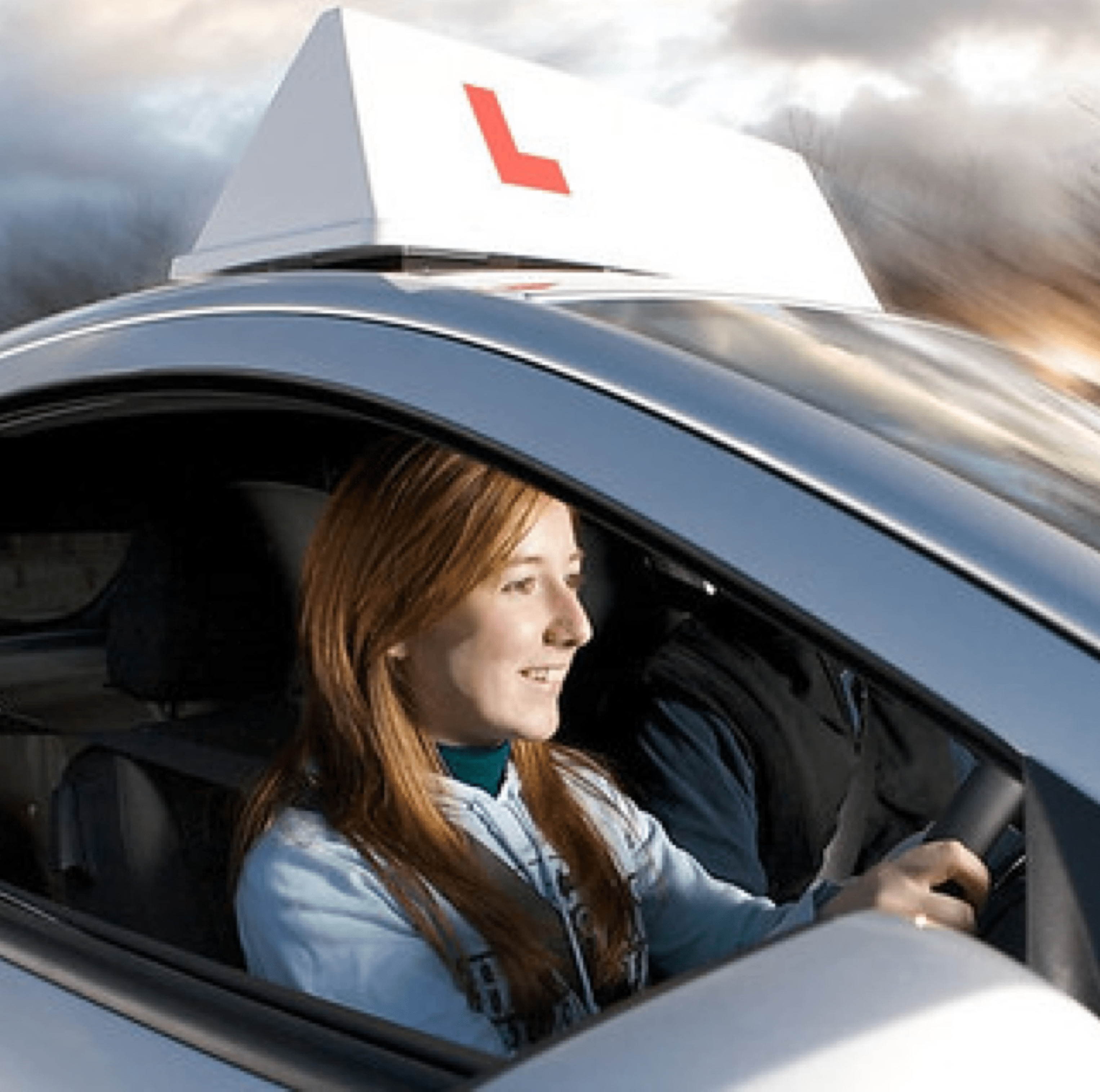 Young woman driving a car with a learner driver sign on the car roof.