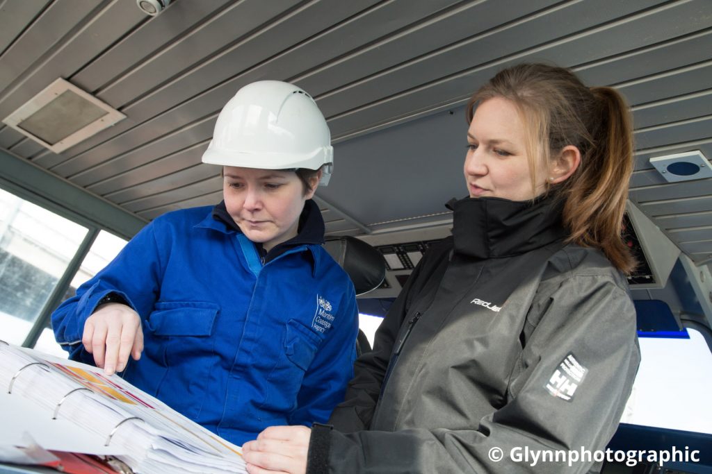 Two female MCA surveyors examining paperwork.
